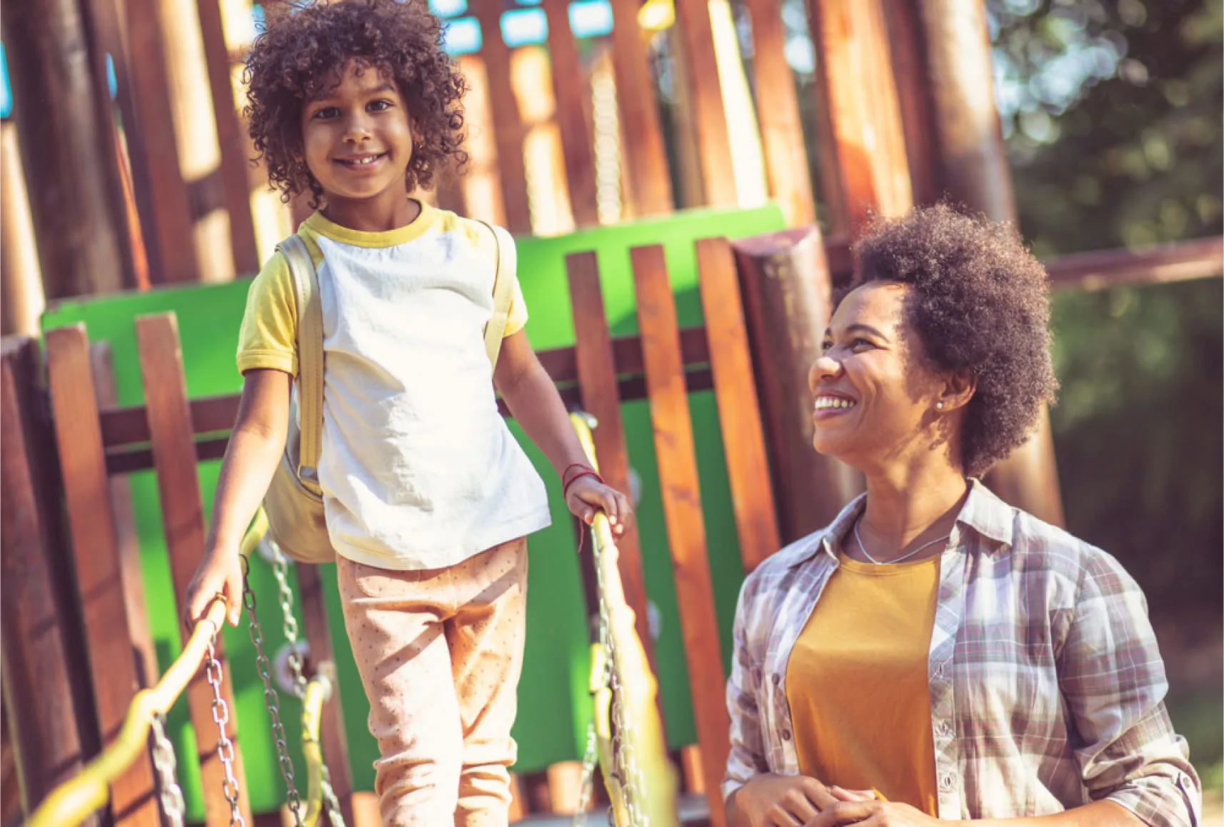 Una mujer con su hija disfrutando los juegos infantiles